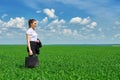Business woman walk on green grass field outdoor. Beautiful young girl dressed in suit, spring landscape, bright sunny day Royalty Free Stock Photo