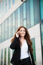 Business woman walks outdoor with smartphone talking to her team Royalty Free Stock Photo