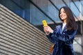 Business woman wearing blue suit using smartphone in an office building.