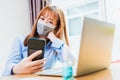 Business woman wearing face mask protective using smart mobile phone for reading SMS message Royalty Free Stock Photo