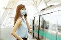 Business woman wearing face mask at train station talking on the mobile phone Royalty Free Stock Photo