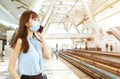 Business woman wearing face mask at train station talking on the mobile phone Royalty Free Stock Photo