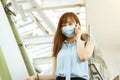 Business woman wearing face mask at train station talking on the mobile phone Royalty Free Stock Photo