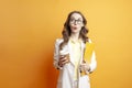 business woman in white suit holds documents and coffee, surprised student girl in glasses looks at copy space Royalty Free Stock Photo