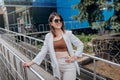 business woman in white suit and sunglasses during break standing near modern office building Royalty Free Stock Photo