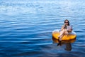 Business woman workaholic working sitting in an inflatable ring on the sea during the holidays, free space. Royalty Free Stock Photo