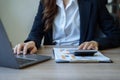 business woman working on calculator to calculate financial data report, accountancy document and laptop computer at office, Royalty Free Stock Photo