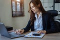 business woman working on calculator to calculate financial data report, accountancy document and laptop computer at office, Royalty Free Stock Photo