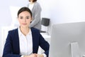 Business woman working with computer in office, female colleague at background. Headshot of Lawyer or accountant at work