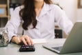 Business woman working on desk office with using a calculator to calculate Royalty Free Stock Photo