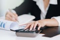 Business woman working with financial data hand using calculator and writing make note with calculate.