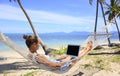 Business woman working in a hammock on the beach Royalty Free Stock Photo