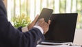 Business woman working with her phone and laptop, Happy woman using mobile phone while working with laptop Royalty Free Stock Photo