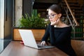 Business woman working on laptop in cafe. Distance job and remote work concept Royalty Free Stock Photo