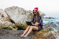 Business woman working on laptop in Christmas holidays on the beach Royalty Free Stock Photo