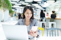 Business woman working on laptop computer and cellphone in office Royalty Free Stock Photo