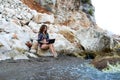 Business woman working on a laptop while sitting on a rock on the beach Royalty Free Stock Photo