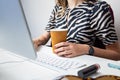 Business woman working in minimalistic office. Young female person with coffee in front of desktop computer at modern workplace Royalty Free Stock Photo