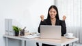 Business woman is working about new business project on laptop and raised your hands when finished work Royalty Free Stock Photo