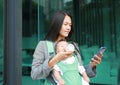 Business woman working by telephone with carrying her infant and feeding her child`s by milk bottle. Busy mother hurrying in the Royalty Free Stock Photo