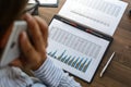 Business woman at workplace at wooden office table analyzes the data, schedules, prices, makes calculations on a calculator Royalty Free Stock Photo