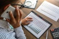 Business woman at workplace at wooden office table analyzes the data, schedules, prices, makes calculations on a calculator Royalty Free Stock Photo