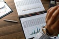 Business woman at workplace at wooden office table analyzes the data, schedules, prices, makes calculations on a calculator Royalty Free Stock Photo