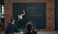 Business Woman writing on blackboard marketing business tools and components. Meeting with co-workers and partners for Royalty Free Stock Photo