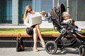 Business woman with child in stroller talking on the phone and working on laptop Royalty Free Stock Photo