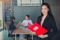 Business woman with folders standing and team mates working in m Royalty Free Stock Photo