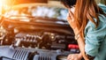 Business women have car problems on the side of the road.The light is golden at sunset. Young women calling car mechanic. Concept