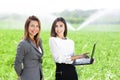 Business women with a laptop in a field with agriculture irrigation system Royalty Free Stock Photo