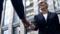 Business woman shaking hand with coworker, interpreter acquainting with client