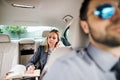 Business woman with smartphone sitting on back seat in taxi car, talking. Royalty Free Stock Photo