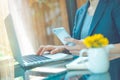 Business women work in a laptop computer and use a cell phone in