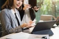 Business women write project ideas and use laptops to edit papers for brainstorming sessions with partners in the office