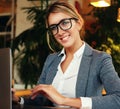 Business wooman using laptop at cafe. Young beautiful girl sitting in a coffee shop and working on computer. . Royalty Free Stock Photo