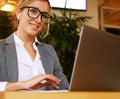 Business wooman using laptop at cafe. Young beautiful girl sitting in a coffee shop and working on computer. Royalty Free Stock Photo