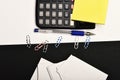 Business and work concept. Office tools on black and white background. Stationery and calculator, top view. Yellow note Royalty Free Stock Photo