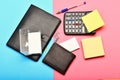 Business and work concept. Office tools isolated on pink and blue background, top view. Calculator, hole punch, business Royalty Free Stock Photo