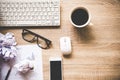 Business workplace with keyboard mouse and crumpled paper balls ,papers with graphs and diagrams .