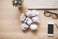 Business workplace with keyboard mouse and crumpled paper balls ,papers with graphs and diagrams .