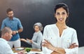 The business world isnt ready for us. Portrait of a businesswoman standing with her arms folded in the boardroom while a