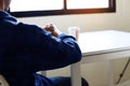 Business young man hand holding coffee cup and thinking creative work in home office. Royalty Free Stock Photo