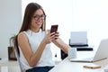 Business young woman using her mobile phone in the office. Royalty Free Stock Photo