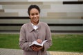 A businesslike African-American businesswoman makes a note in a notebook. Royalty Free Stock Photo