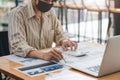 Businessman or accountant wear mask working on desk office with using a calculator to calculate the numbers, finance Royalty Free Stock Photo