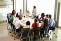 Businessman Addressing Meeting Around Boardroom Table Royalty Free Stock Photo