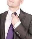 Businessman adjusting his tie against white
