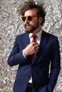 Businessman adjusting his tie, holding one hand in pocket Royalty Free Stock Photo